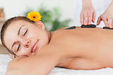 Delighted woman having a hot stone massage 