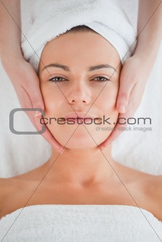 Portrait of a charming brunette having a facial massage