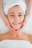 Portrait of a smiling brunette having a facial massage