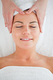 Portrait of a happy woman enjoying a facial massage