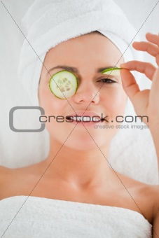 Young woman with cucumber slices on the face