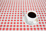 A cup of coffe on a tablecloth