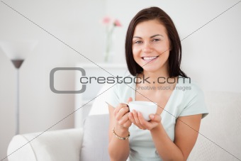 Close up of a dark-haired woman drinking tea