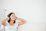 Delighted brunette listening to music
