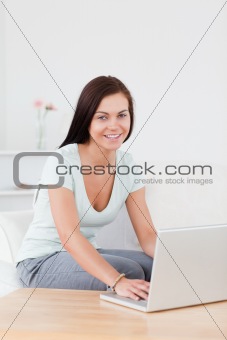 Portrait of a young woman typing on her laptop
