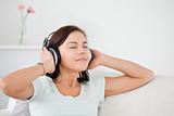 Charming dark-haired woman listening to music