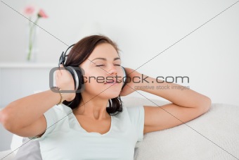 Charming dark-haired woman listening to music