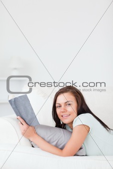 Charming woman on a sofa with a book
