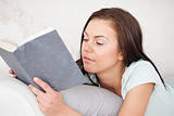 Close up of a woman on a sofa reading a book