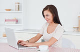 Young woman using her laptop and having a tea