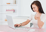 Charming woman using her laptop and having a tea