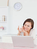 Portrait of a woman using her laptop and having a tea