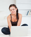 Cute dark-haired woman using her laptop