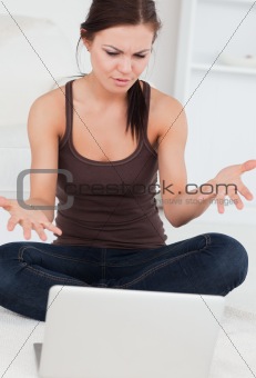 Close up of an angry dark-haired woman using her laptop