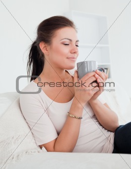 Cute brunette enjoying a cup of tea