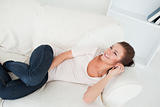 Smiling brunette calling while lying on her sofa