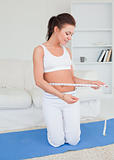 Fit woman measuring her belly