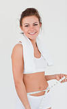 Athletic woman with a towel measuring her belly