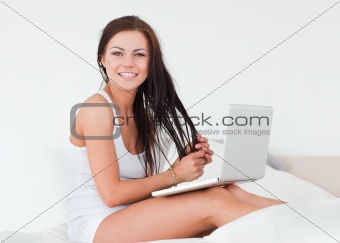Smiling brunette with her laptop