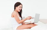 Laughing brunette with her laptop 