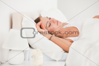 Young brunette sleeping in her bed
