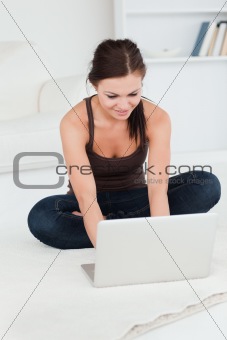 Cute young brunette using her laptop