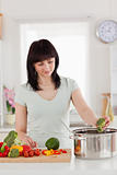 Beautiful brunette woman cooking vegetables