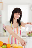 Good looking brunette woman using a mixer while standing