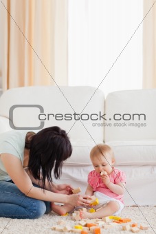 Beautiful woman playing with her baby in while sitting on a carp