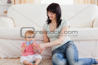 Attractive woman holding her baby in her arms while sitting on a