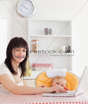 Good looking brunette woman relaxing with her laptop next to her