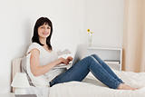 Beautiful brunette woman relaxing with her laptop while sitting 