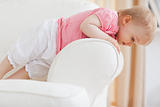 Cute blond baby standing on a sofa