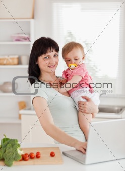 Cute woman holding her baby in her arms
