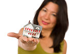 Attractive Multiethnic Woman Holding a Small House Out In Front of Her Isolated on a White Background.
