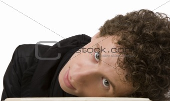 The young man with curly hair has bent to a table