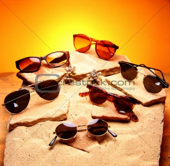 Six sunglasses over sand and stones