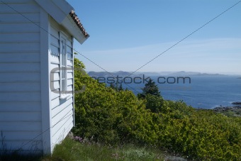 Small, white cabin with seaview
