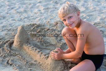 Smiling boy playing on sandy beach