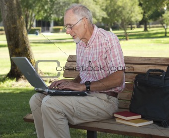 Senior man using laptop outdoors
