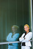 Pensive business woman standing near office building 
