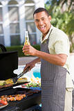 Man Barbequing In A Garden
