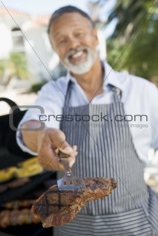 Man Barbequing In A Garden