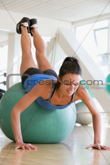 Woman Doing Push Ups On Swiss Ball At Gym