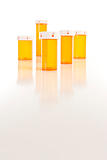 Several Different Sized Empty Medicine Bottles on Reflective Surface.