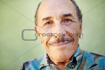 aged latino man smiling at camera