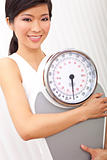 Oriental Asian Chinese Woman Holding Weighing Scales at Gym 