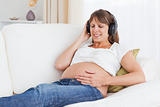 Smiling pregnant woman listening to music
