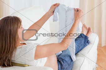 Good looking pregnant woman looking at a baby grow while lying o