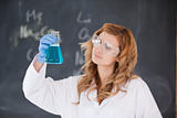 Female scientist looking at a flask